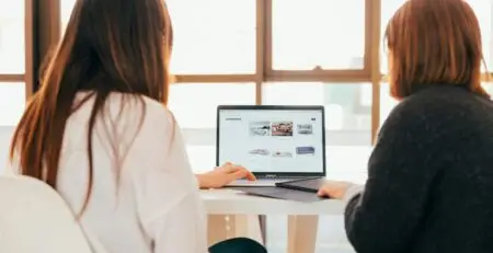 Duas mulheres de costas vendo um notebook