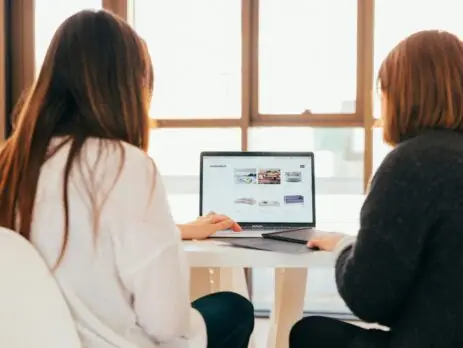 Duas mulheres de costas vendo um notebook